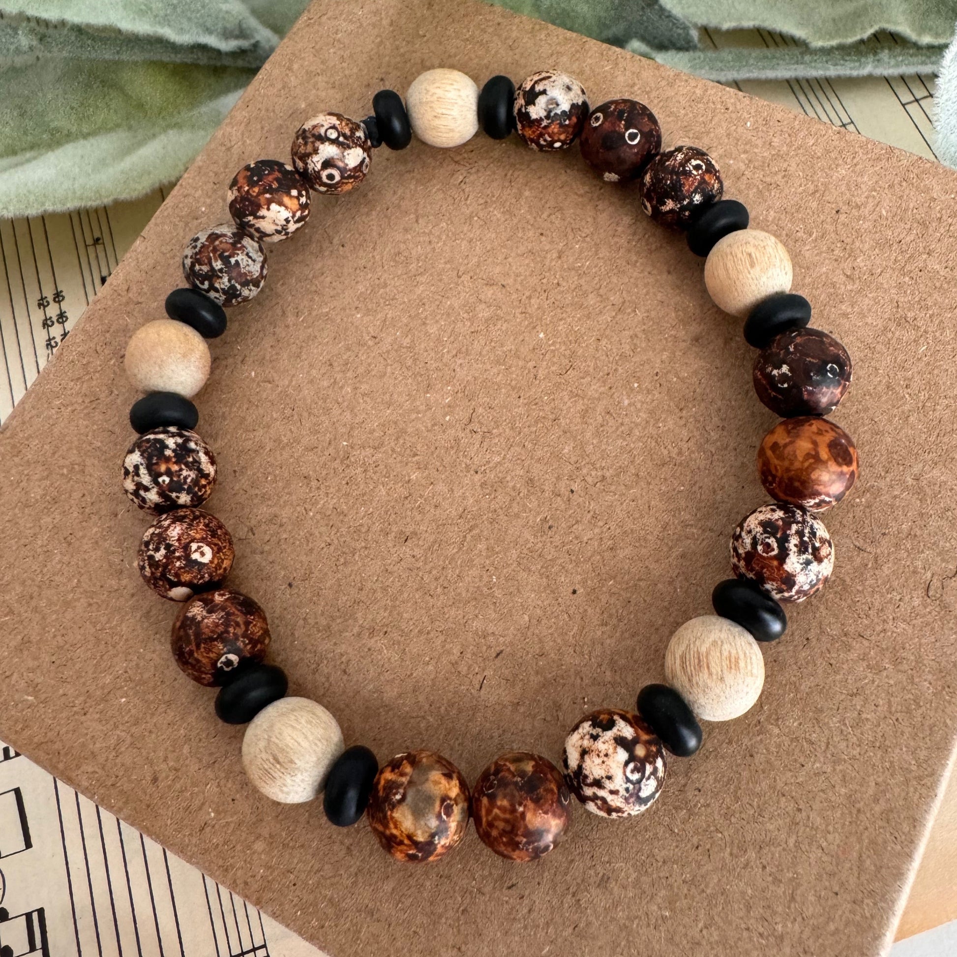 Stunning 8mm wood agate beaded stretch bracelet with onyx and wood bead accents.